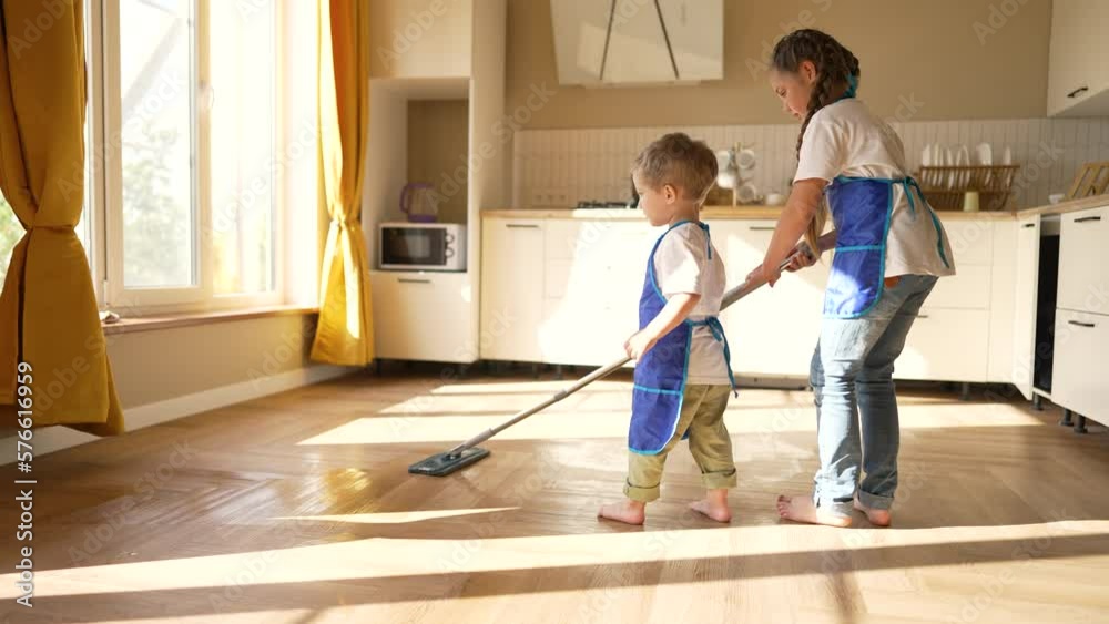 Happy children at home mopping floors.Clean house cleaning.Cute child work at home.Clean