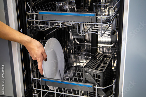 Built-in dishwasher in the kitchen, washing dishes. Plates, cups, glasses are worth washing. Household chores, everyday life