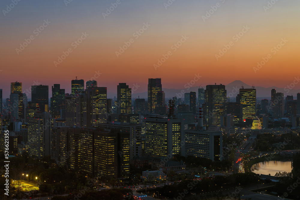 Sunset in Tokyo. View of the city center with modern skyscrapers and the iconic Mount Fuji