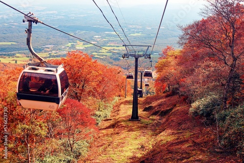 Scenery of Nasu Gondola gliding among beautiful fall colors on the hillside of Mountain Jeans, which is famous for leaf-peeping in autumn and skiing in winter, in Nasu, Tochigi Prefecture, Japan
