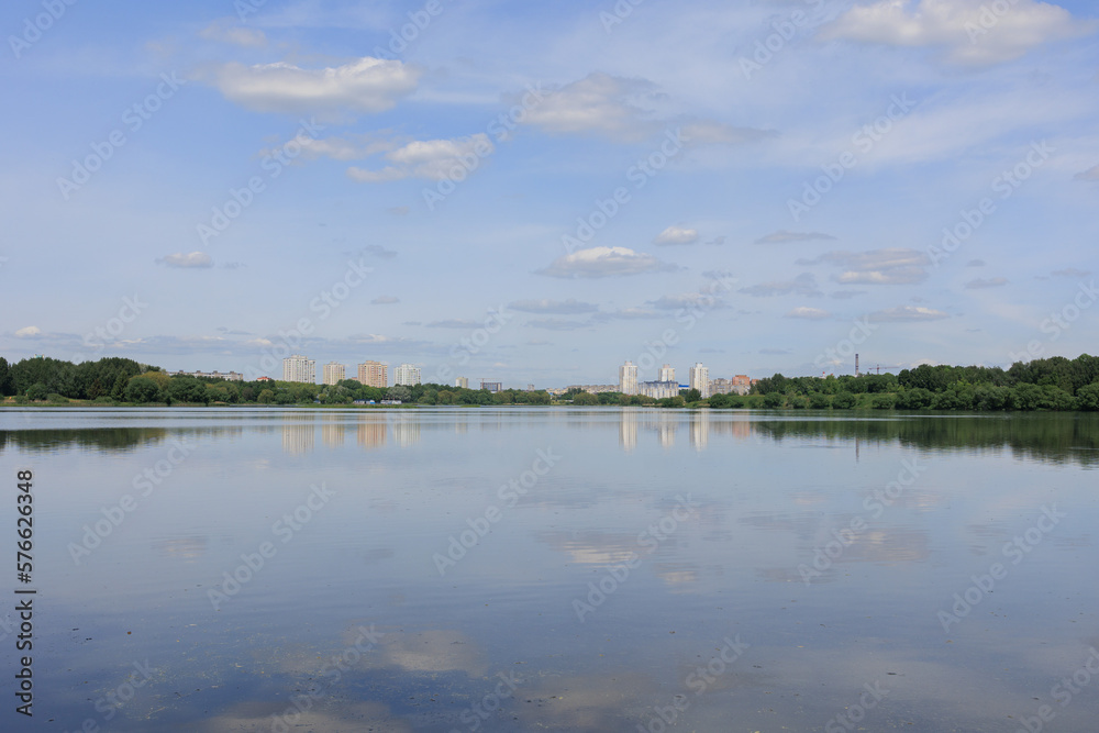 Buildings and houses standing on the shore of a lake, river or sea.
Cityscape and urban scene.