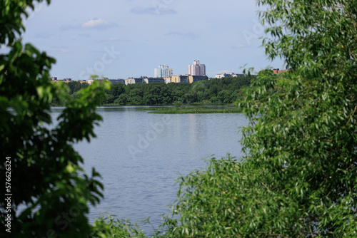 Buildings and houses standing on the shore of a lake, river or sea. Cityscape and urban scene.