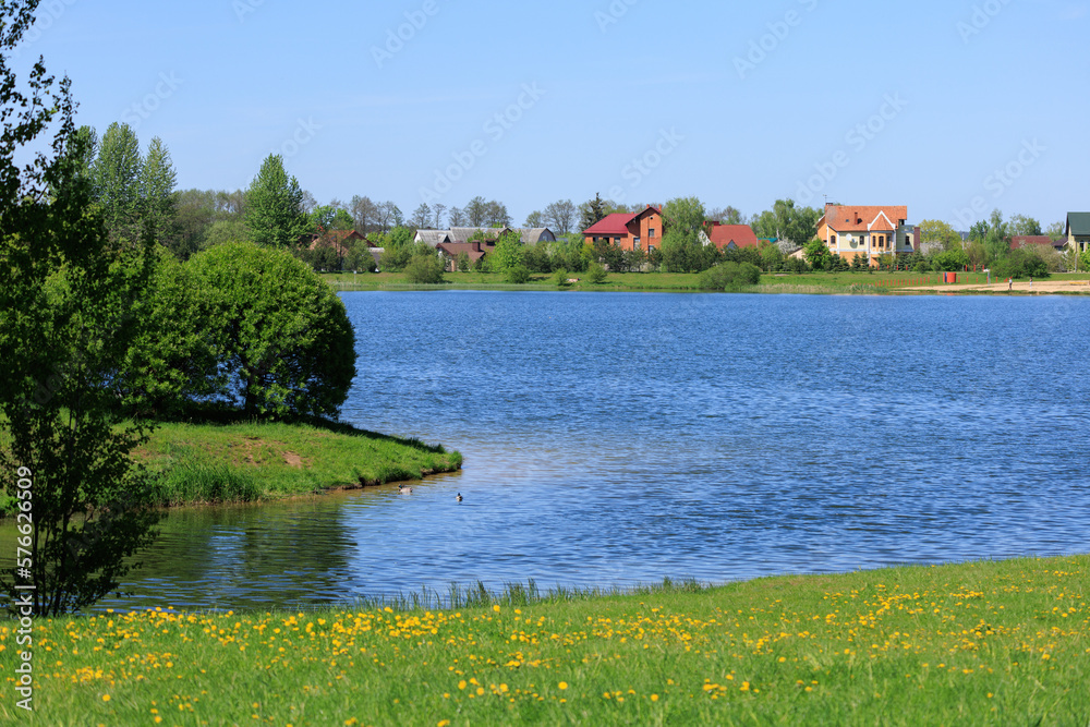 Obraz premium Buildings and houses standing on the shore of a lake, river or sea.