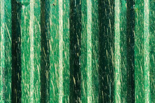 Green zinc fence background with paint spots and splashes.