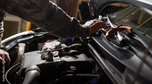 Hands of car mechanic. Protective gloves and tools. Auto service. Car repairing and maintenance.