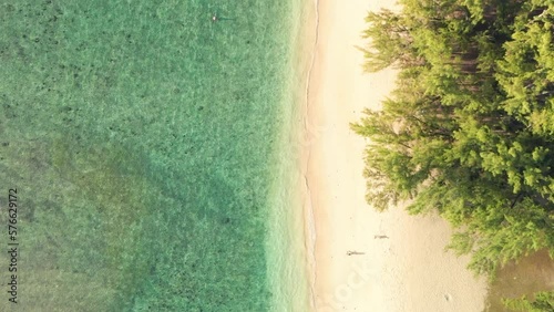 Wallpaper Mural  waves gently lapping at the shore as two people walk on the sand of Flic en Flac beach Torontodigital.ca