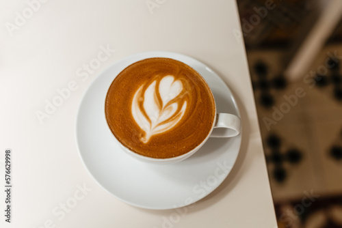 Delicious double cappuccino with beautiful foam in a white mug view from above.