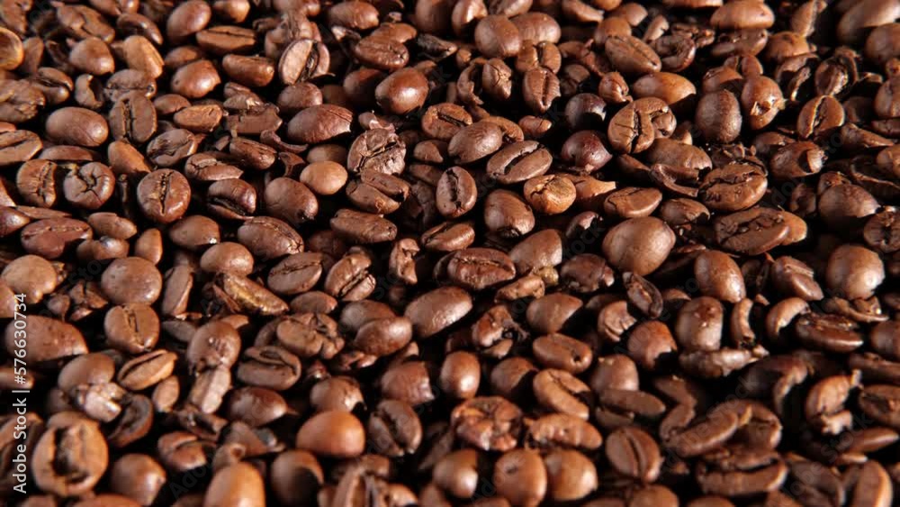 Coffee beans background. Texture of coffee beans close up. Dark brown roasted coffee is spinning. Abundance. Concept for coffee product advertising. Selective Focus. Border design with copy space Coffee beans background. Texture of coffee beans close up. Dark brown roasted coffee is spinning. Abundance. Concept for coffee product advertising. Selective Focus. Border design with copy space