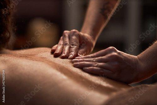 Masseuse using petrissage technique when massaging back of client