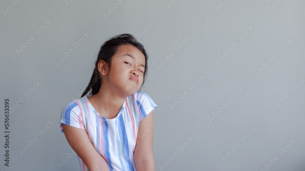 little asian girl showing annoyed face over gray. little asian girl showing annoyed face over gray.