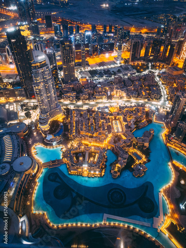 Photography Aerial view of Downtown Dubai with roads, Dubai Mall and the fountain by night,