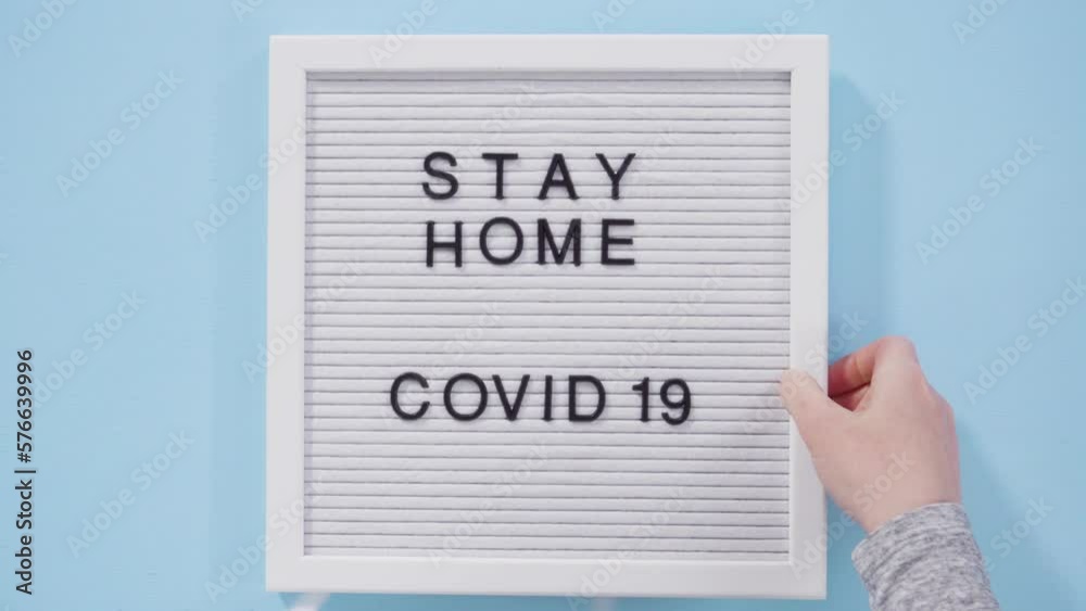 STAY HOME and COVID-19 sign on message board with a blue medical mask.