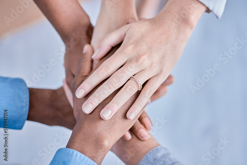 Business people, diversity and hands together above in trust, partnership or collaboration at the office. Group of diverse employee workers piling hand in teamwork, support or agreement in solidarity