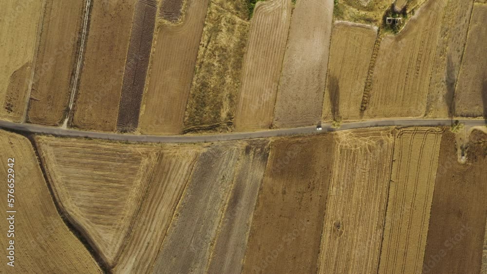 Aerial view of a car driving a road in countryside, Sicily, Italy.
