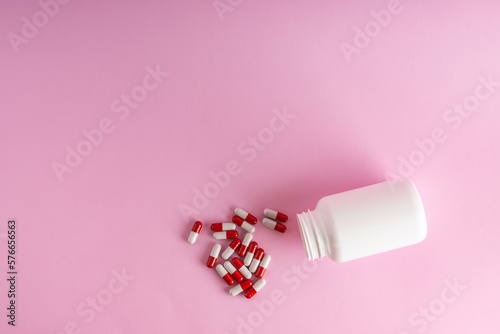 A jar for medicine on a pink background.