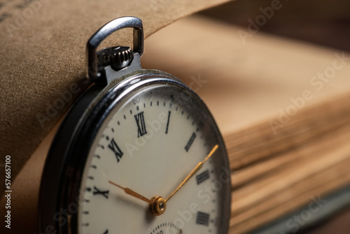 Vintage pocket watch on the background of old books