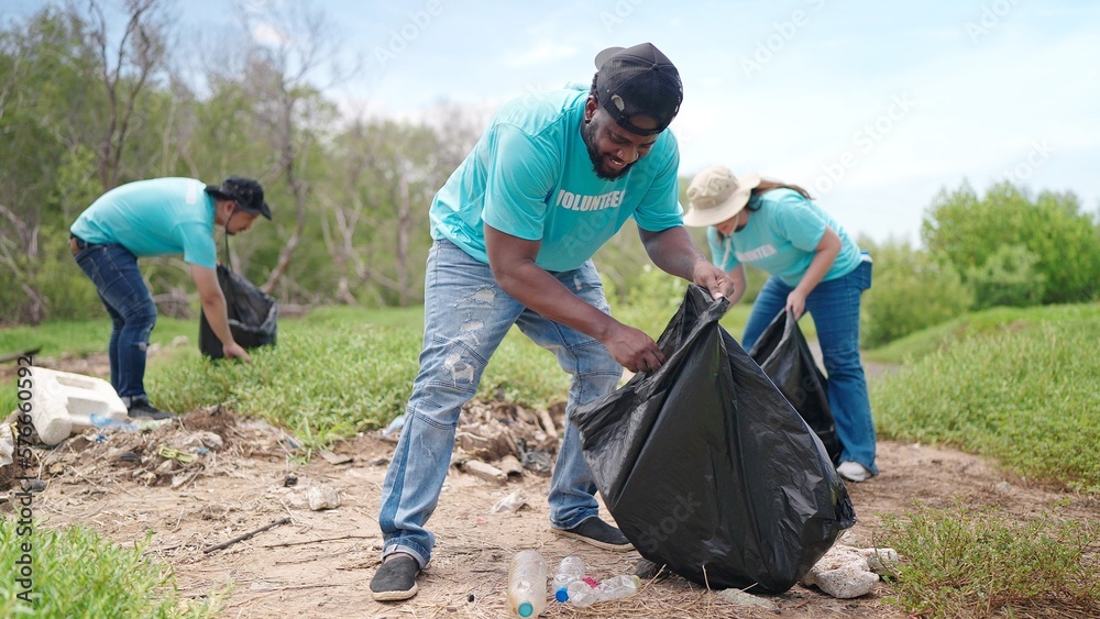 Group of volunteers are helping to pick up waste by garbage bags cleaning in green forest. CSR activity. Corporate Social Responsibility. Environmental problem. Environment day Group of volunteers are helping to pick up waste by garbage bags cleaning in green forest. CSR activity. Corporate Social Responsibility. Environmental problem. Environment day