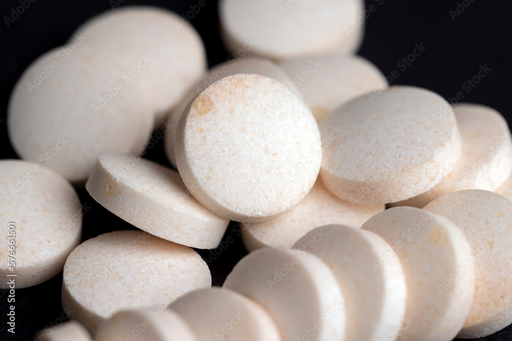 White and yellow medical medicines on a black background White and yellow medical medicines on a black background