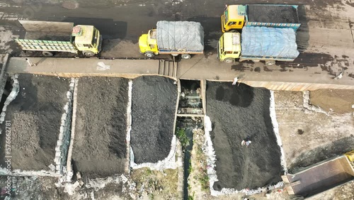 Kishoreganj, Bangladesh - 06 November 2022: Aerial view of people with trucks working along the riverbank unloading coal, Bhairab Upazila. photo