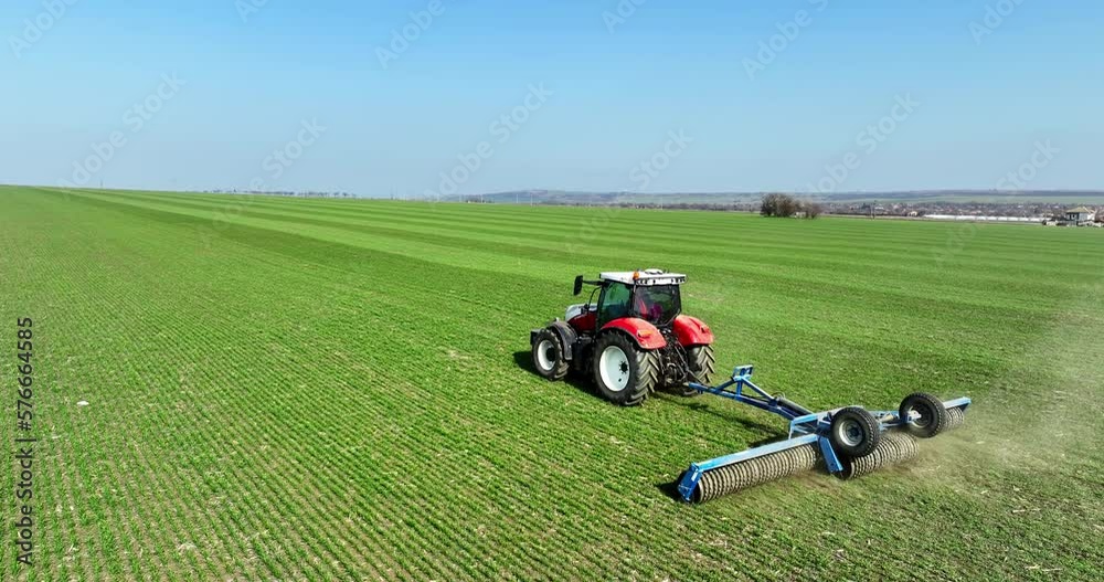 Tractor with a roller tillage on spring field, aerial 4k video. Soil rolling supports germination and is the basis for good harvesting