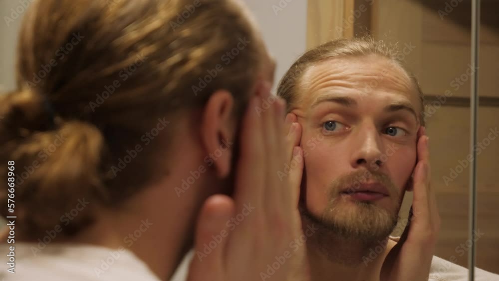 Man check his aging face. Man check his aging face.