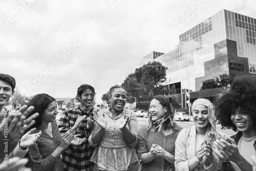 Young diverse people celebrating together outdoor - Focus on african curvy girl face - Black and white editing