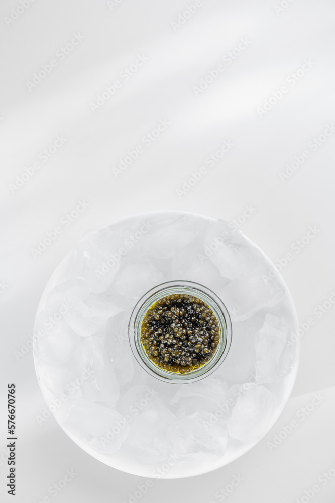 Premium caviar black in glass jar and ice cube