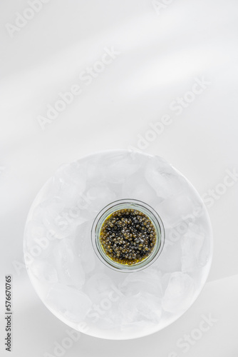Premium caviar black in glass jar and ice cube