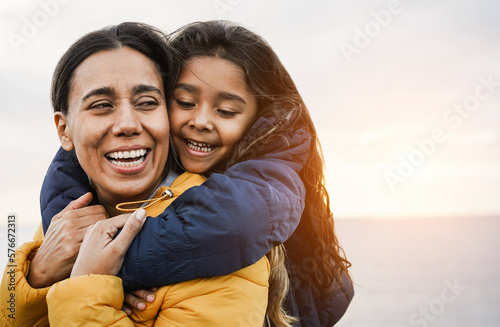 фотографія Happy latin mother and daughter having fun together during winter time - Mom day