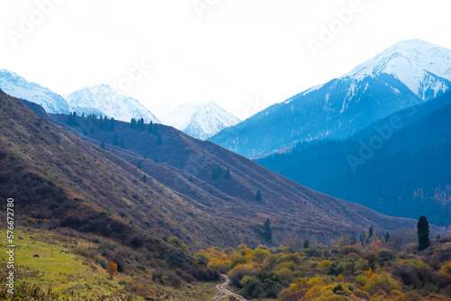 Panorama of a mountain landscape in northern China with snow-capped mountains. Foggy autumn day with first snow in Qitai county Xinjiang Uygur Autonomous Region, China.