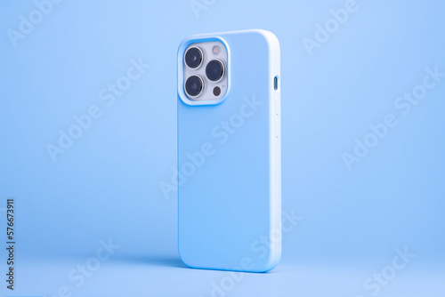 iPhone 14 and 13 Pro Max in light blue case back side view isolated on blue background, monochrome color phone cover mock up