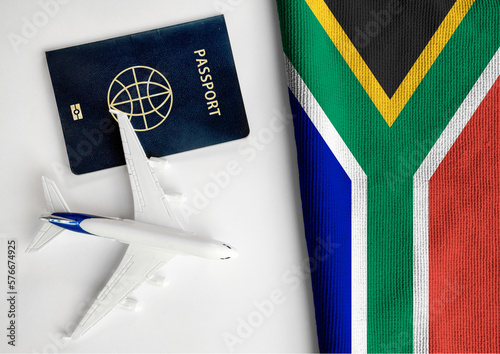 Flag of South Africa with passport and toy airplane. Flight travel concept 