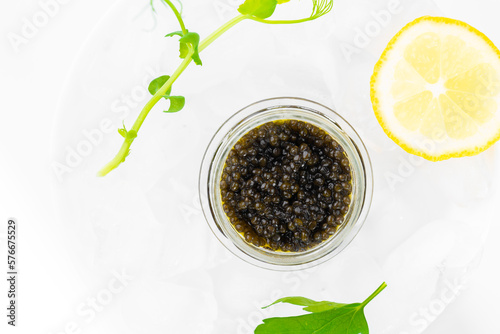 Obraz na płótnie Appetizers of natural sturgeon black caviar, lemon and parsley w salonie