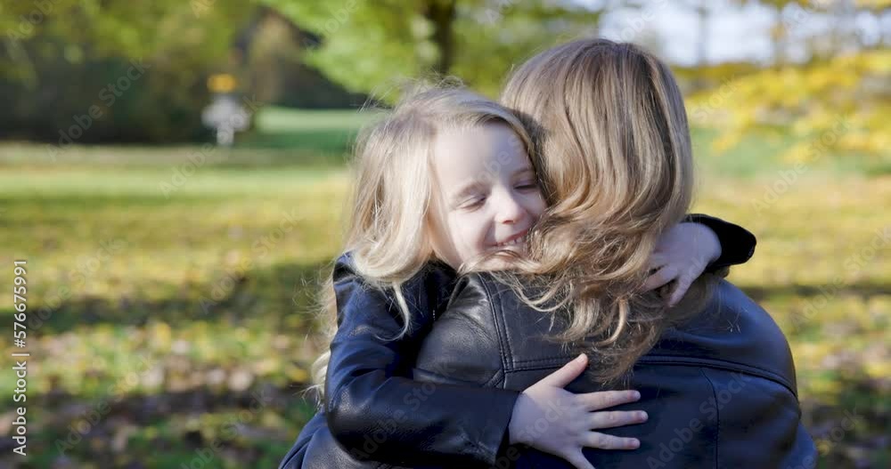 Mother and child daughter hugging and embracing at park Mother and child daughter hugging and embracing at park