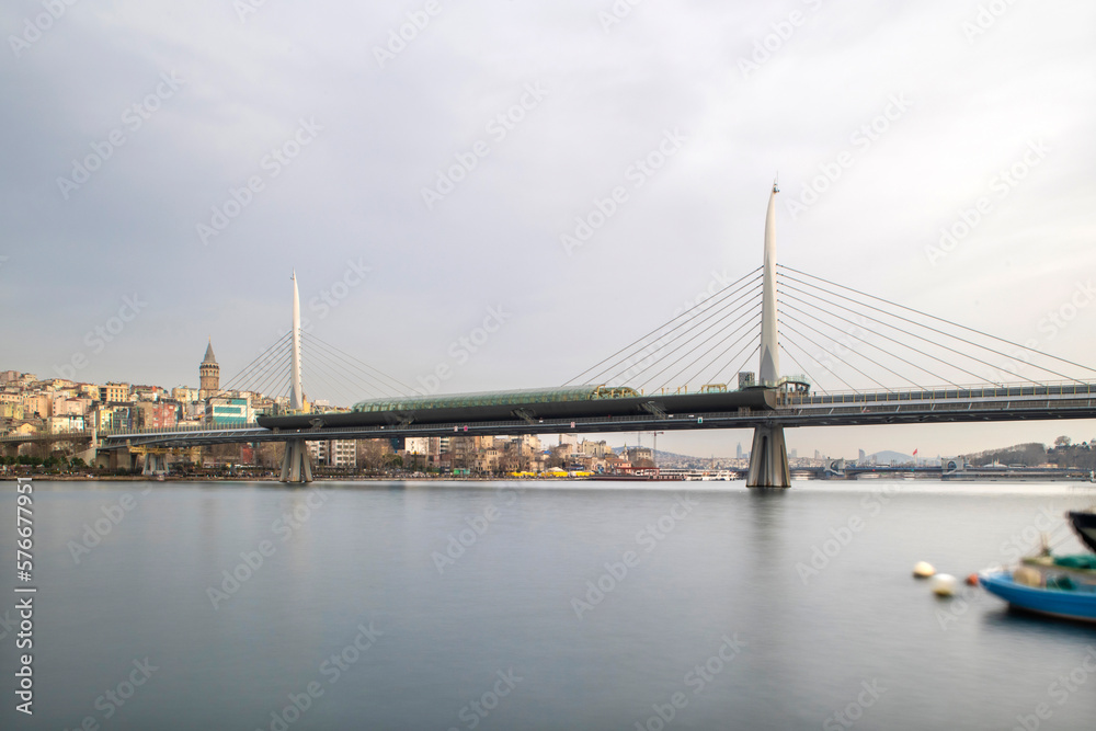 Obraz premium Long exposure. View of Haliç Metro Bridge connecting Azapkapı (Beyoğlu) and Unkapanı (Fatih) (Halic Metro Bridge). blue sky Istanbul Turkey 