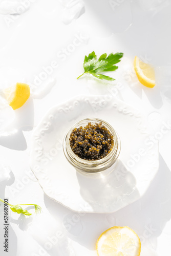 Obraz na płótnie Appetizers of natural sturgeon black caviar, lemon and parsley w salonie