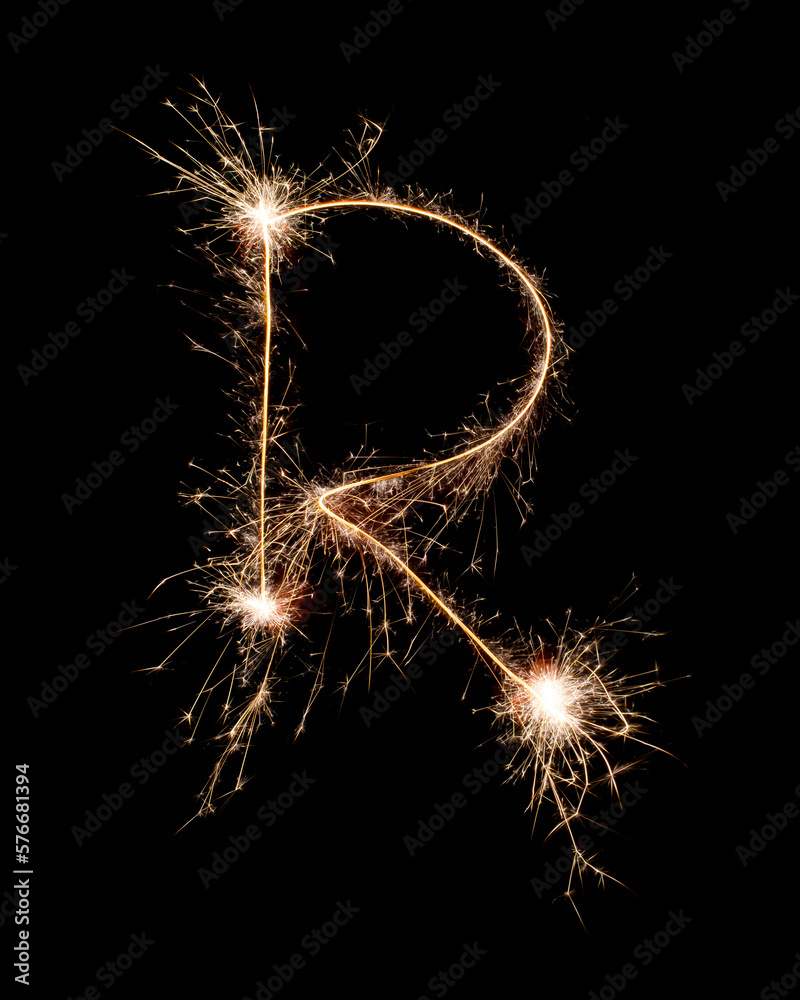 Sparkling burning creative letter R isolated on black background. Beautiful glowing golden overlay object for design holiday greeting card. Creative lettering R written with burning sparklers