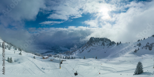 panorama of fresh snow in tyrolean ski resort with ski tracks sky and gondola cabin cable car