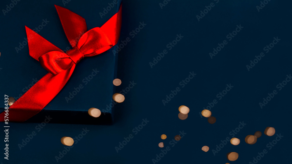 blue gift box with a red bow on blue background.