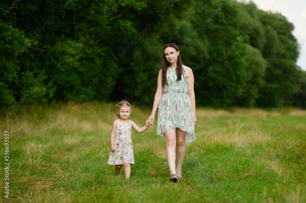 Portraits of joyful mother and daughter spend time together, enjoy happy family time, walk in the park. Mother's day. Portraits of joyful mother and daughter spend time together, enjoy happy family time, walk in the park. Mother's day.