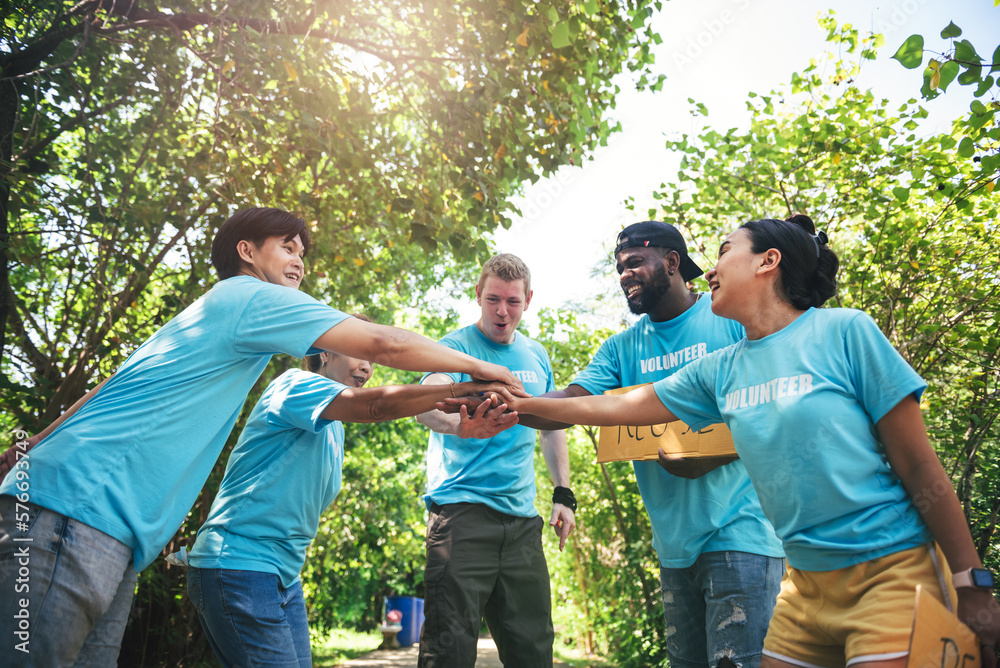 Group of multiethnic people male and female volunteer putting their hands together for showing team unity and teamwork. Group of multiethnic people male and female volunteer putting their hands together for showing team unity and teamwork.