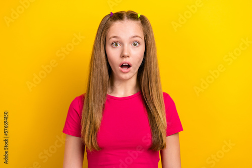 Photo of impressed astonished schoolgirl with straight hairstyle wear pink t-shirt staring at discount isolated on yellow color background