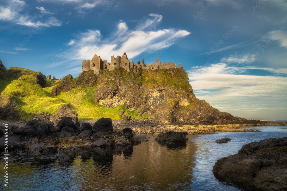 View from a shoreline on Dunluce Castle nested on the edge of cliff, part of Wild Atlantic Way, Northern Ireland. Filming location of popular TV show Game of Thrones