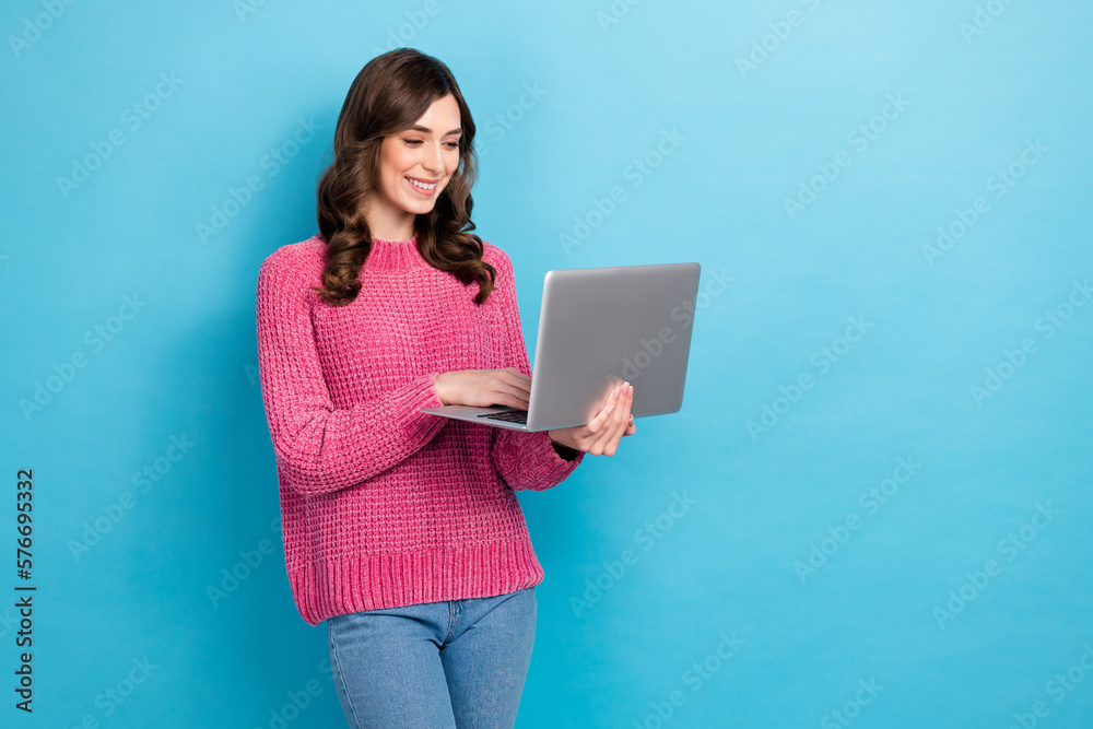 Photo of positive beautiful woman programmer satisfied it specialist writing email online hold dell laptop isolated on blue color background Photo of positive beautiful woman programmer satisfied it specialist writing email online hold dell laptop isolated on blue color background
