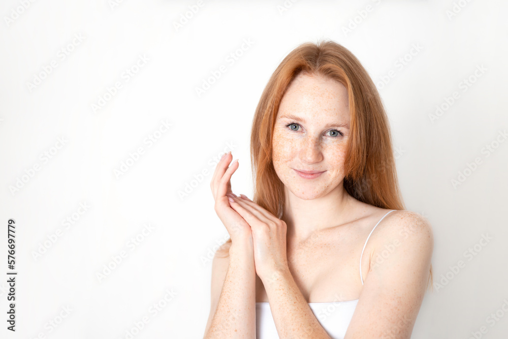 A natural portrait of a beautiful young red-haired girl on a white background. Light makeup. Self-care. freckles. Space for text. A natural portrait of a beautiful young red-haired girl on a white background. Light makeup. Self-care. freckles. Space for text.