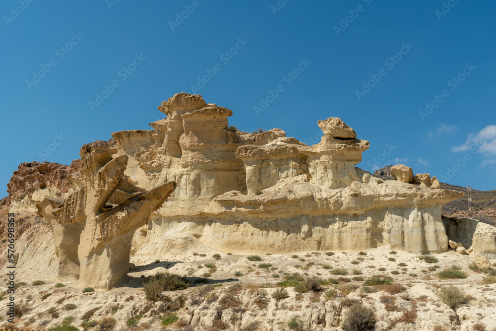 The surreal sandstone rocks of Bolnuevo with sunlight in blue sky with light clouds near Mazarron on the Costa Calida.