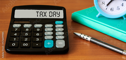 Tax day words written on calculator display, business concept photo