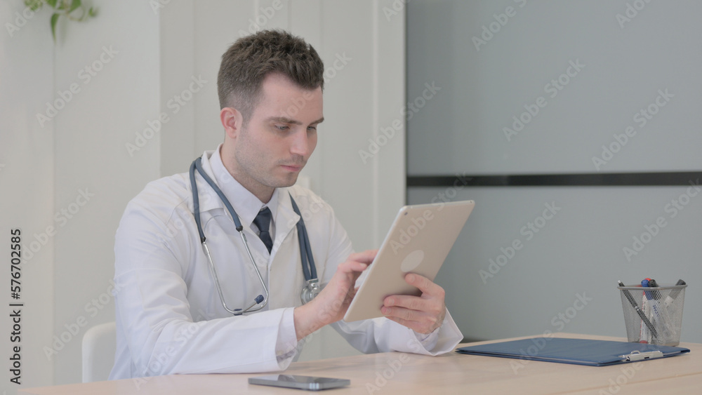 Young Doctor Browsing Tablet in Clinic Young Doctor Browsing Tablet in Clinic