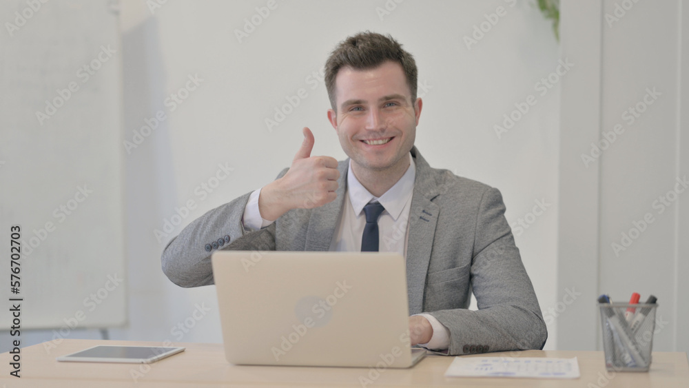 Thumbs Up by Young Businessman Working on Laptop Thumbs Up by Young Businessman Working on Laptop