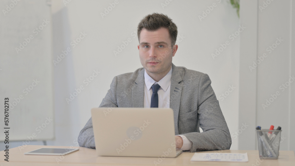 Young Businessman Shaking Head in Rejection while Working on Laptop Young Businessman Shaking Head in Rejection while Working on Laptop
